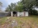Shed features an open area and closed off room, surrounded by overgrown grass at 11625 Churchill St, Orlando, FL 32817