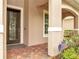 Inviting front porch with decorative glass door, brick flooring, and elegant architectural details at 11885 Padua Ln, Orlando, FL 32827
