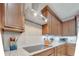 Close up of kitchen features stainless steel range hood, cooktop, granite counters, white subway tile backsplash, and wood cabinets at 11885 Padua Ln, Orlando, FL 32827