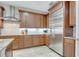 Modern kitchen features stainless steel refrigerator, granite counters, white subway tile backsplash, and rich wood cabinetry at 11885 Padua Ln, Orlando, FL 32827