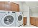 Bright laundry room featuring a front loading washer and dryer set, overhead cabinets, and a built-in sink at 11885 Padua Ln, Orlando, FL 32827