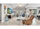 Open living room featuring tile floors, a modern entertainment console, and access to the dining room and kitchen at 11885 Padua Ln, Orlando, FL 32827