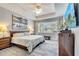 Bright main bedroom features tray ceiling, ceiling fan, large windows and an en-suite bathroom at 11885 Padua Ln, Orlando, FL 32827