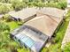 Aerial view of screened-in pool and home, showing backyard with lush landscaping at 11885 Padua Ln, Orlando, FL 32827