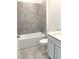 Bathroom features a tub with shower, tiled walls, and white vanity at 1374 Brentwood Dr, Kissimmee, FL 34746
