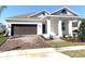 Charming single-story home with a brick driveway, two-car garage, and covered front porch with white pillars at 1374 Brentwood Dr, Kissimmee, FL 34746