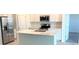 Modern kitchen with a stone countertop island, stainless steel appliances, and white cabinets at 1374 Brentwood Dr, Kissimmee, FL 34746