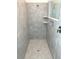 A tiled walk-in shower has a glass door, built-in shelves, and modern fixtures at 1374 Brentwood Dr, Kissimmee, FL 34746