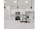 Kitchen with stainless appliances, quartz countertops, white cabinets and stylish lighting at 14961 Sw 38Th Cir, Ocala, FL 34473