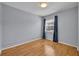 Cozy bedroom featuring light blue walls, hardwood floors, and a window with blue curtains at 151 N Orlando Ave # 115, Winter Park, FL 32789