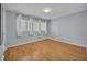 Neutral bedroom with a view featuring light-colored walls, multiple windows, and hardwood floors at 151 N Orlando Ave # 115, Winter Park, FL 32789
