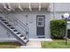 Gray apartment building with metal stairs leading to the door of unit 115 and a small lawn at 151 N Orlando Ave # 115, Winter Park, FL 32789