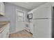 Cozy kitchen featuring white appliances, a door to the backyard, and light-colored flooring at 151 N Orlando Ave # 115, Winter Park, FL 32789