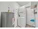 Functional laundry room with stacked washer and dryer, plus a water heater and storage at 151 N Orlando Ave # 115, Winter Park, FL 32789