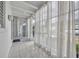 Bright sunroom with large windows, white ceilings, tile floors, and sheer white curtains at 151 N Orlando Ave # 115, Winter Park, FL 32789