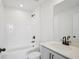 Modern bathroom with a combined tub and shower, white subway tile, and vanity with black hardware at 15483 Hamlin Park Drive, Winter Garden, FL 34787