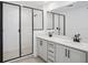 A modern bathroom featuring a double vanity, glass shower, and contemporary fixtures at 15483 Hamlin Park Drive, Winter Garden, FL 34787