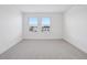 A bright, unfurnished bedroom features neutral carpet, a window and white walls at 15483 Hamlin Park Drive, Winter Garden, FL 34787