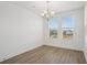 A spacious dining room with wood floors and a chandelier offers an inviting area for enjoying meals with Gathering and friends at 15483 Hamlin Park Drive, Winter Garden, FL 34787