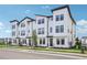 Charming white townhomes feature modern design, black accents, and manicured landscaping in a vibrant community at 15483 Hamlin Park Drive, Winter Garden, FL 34787