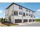 Exterior view of white modern townhomes with brown garage doors and second story patios at 15483 Hamlin Park Drive, Winter Garden, FL 34787