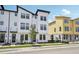 Contemporary white townhome showcases clean lines and dark accents, complemented by fresh landscaping at 15483 Hamlin Park Drive, Winter Garden, FL 34787