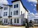New townhouse with white siding, black trim, and a modern design under a sunny blue sky at 15483 Hamlin Park Drive, Winter Garden, FL 34787