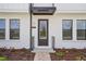 Close-up of home's front entrance showcases a modern door and clean design with landscaped walkway at 15483 Hamlin Park Drive, Winter Garden, FL 34787