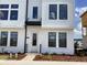 A well-lit, modern townhouse featuring a front door with black trim and landscaping at 15483 Hamlin Park Drive, Winter Garden, FL 34787