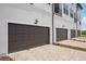 Brown garage doors with brick pavers in front of them at a townhome complex at 15483 Hamlin Park Drive, Winter Garden, FL 34787