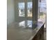 A view over the kitchen island of a bright kitchen and living space in a newly built home at 15483 Hamlin Park Drive, Winter Garden, FL 34787
