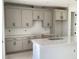 Modern kitchen showcasing gray cabinets with black hardware and a quartz countertop island at 15483 Hamlin Park Drive, Winter Garden, FL 34787