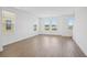 Open concept living room features wood floors and bright windows offering ample sunlight at 15483 Hamlin Park Drive, Winter Garden, FL 34787