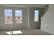 A living room with three large windows and neutral walls in a newly built home at 15483 Hamlin Park Drive, Winter Garden, FL 34787