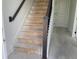 Staircase with dark wooden handrail and light steps, leading to the upper level at 15483 Hamlin Park Drive, Winter Garden, FL 34787