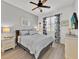 Cozy bedroom offers natural light, wood-look floors, and neutral decor; furnished with dresser at 162 Plumoso Loop, Davenport, FL 33897