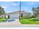 Charming single-story home with a well-manicured lawn, lush landscaping, and a two-car garage at 162 Plumoso Loop, Davenport, FL 33897