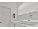 Bright laundry room featuring a modern washer and dryer, fire extinguisher and a window with white blinds at 162 Plumoso Loop, Davenport, FL 33897