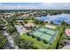 An aerial view of the community, highlighting the lake, tennis courts, and manicured landscaping at 1803 Glenbay Ct, Windermere, FL 34786