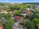 Aerial view of a luxury home showcasing a red-tile roof, screened-in pool, and mature trees at 1803 Glenbay Ct, Windermere, FL 34786
