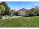 Expansive backyard boasts a unique paved patio, lush lawn, and tropical landscaping at 1803 Glenbay Ct, Windermere, FL 34786