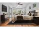 Main bedroom with hardwood floors, ceiling fan, and sliding glass door to the pool area at 1803 Glenbay Ct, Windermere, FL 34786
