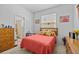 Cozy bedroom with a red bedspread, bright walls, and well-lit bathroom access at 235 Largovista Dr, Oakland, FL 34787