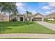 Charming single-story home features a manicured lawn, mature landscaping and two car garage at 235 Largovista Dr, Oakland, FL 34787