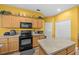 Functional kitchen features wood cabinets, black appliances and an island at 235 Largovista Dr, Oakland, FL 34787