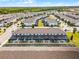 Community aerial view featuring screened-in patios, landscaping, and nearby pond surrounded by houses at 2432 Tangier Dr, Kissimmee, FL 34747
