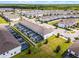 Aerial view showcasing a neighborhood featuring houses with screened-in patios, green spaces, and trees at 2432 Tangier Dr, Kissimmee, FL 34747