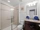 Bathroom featuring glass-enclosed shower, granite vanity, and decorative towel accents at 2432 Tangier Dr, Kissimmee, FL 34747