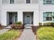 Close-up of a townhome entryway showcasing dual doorways, fresh landscaping, and a paved walkway at 2432 Tangier Dr, Kissimmee, FL 34747