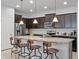 Modern kitchen featuring an island with bar stools, stainless steel appliances, and pendant lighting at 2432 Tangier Dr, Kissimmee, FL 34747